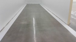 1 foot painted stripes around the border of polished concrete flooring.